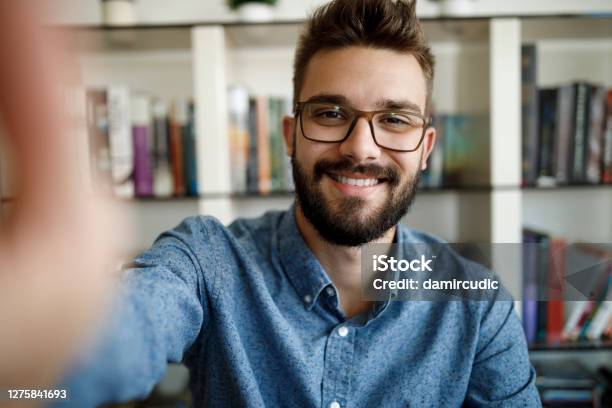 Smiling Young Man Having Online Conference From Home Stock Photo - Download Image Now