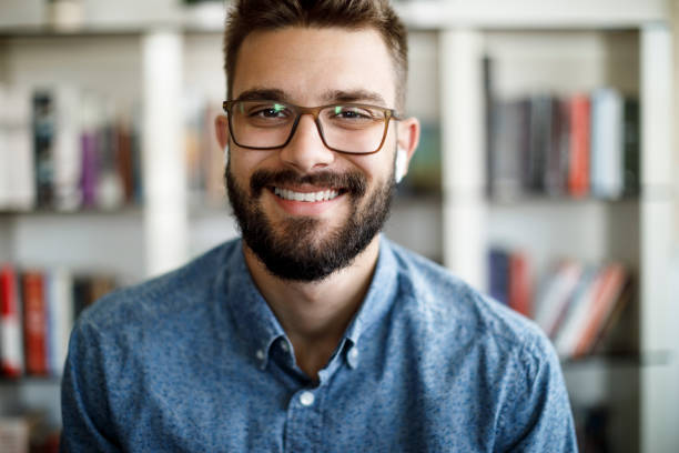 Smiling young man having online conference from home office Smiling young man having online conference from home office bosnia and herzegovina photos stock pictures, royalty-free photos & images