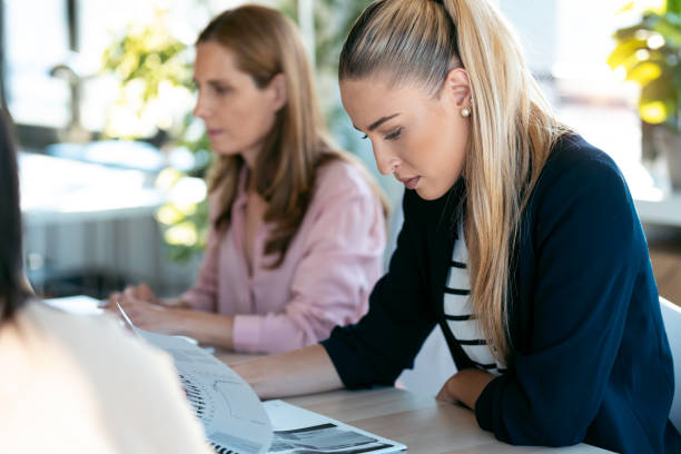 istock Concentrated young blonde woman reading some documents sitting on coworking space. 1275842353