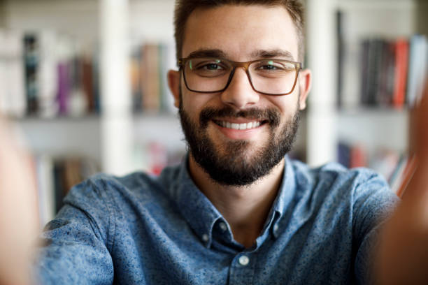istock Smiling young man having online conference from home 1275842519