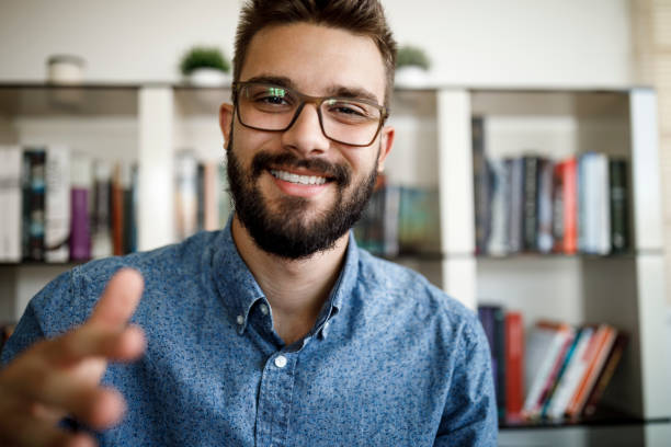 istock Smiling young man having online conference from home office 1275842556