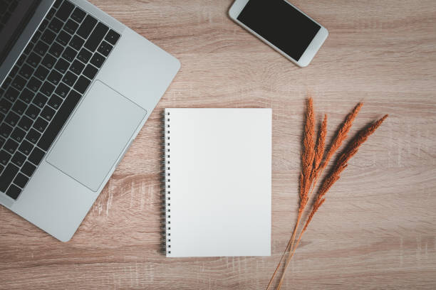 istock Office desk with blank notebook and dry flowers decoration. 1275844610