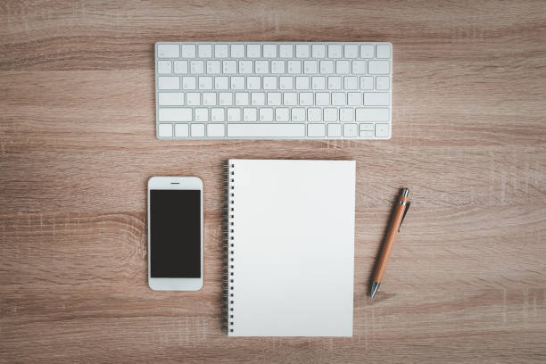 istock Top view of office desk with notebook and keyboard. 1275844650