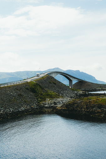 Dramatic view of the beautiful bridge, road and the camper car driving above the ocean in South Norway