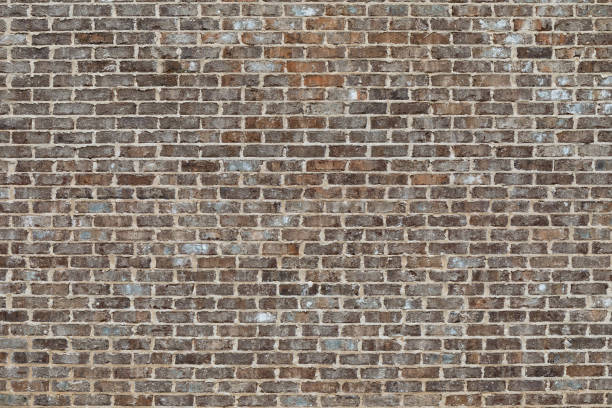 istock Weathered brick wall with mortar and concrete on the face 1275847282