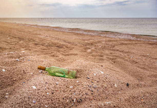 istock message in green bottle on the beach 1275848612
