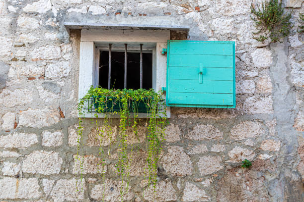 istock Closeup of an old natural stone wall with a window typical texture 1275849004
