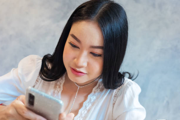 istock Young thai woman concentrate looking at mobile screen 1275850477
