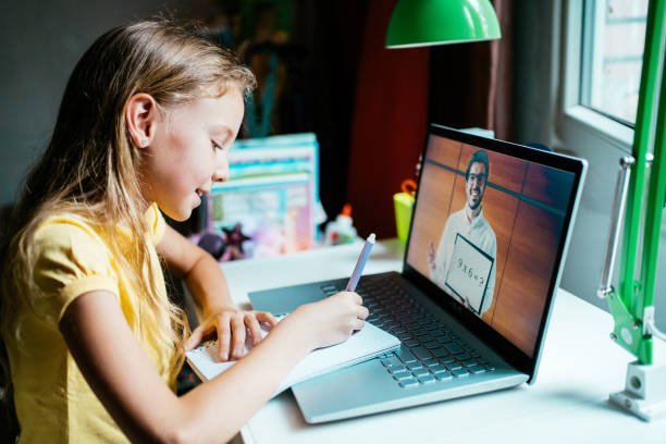 istock Schoolgirl studying with video online lesson at home. 1275851396