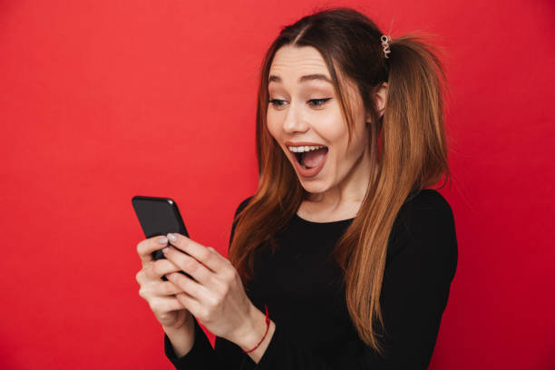 istock Cute excited screaming lady chatting by mobile phone. 1275851489