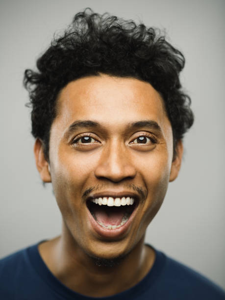 Portrait of real pakistani man with shouting expression Close up portrait of young adult middle eastern man with shouting expression against white gray background. Vertical shot of real pakistani man smiling in studio with short black hair. Photography from a DSLR camera. Sharp focus on eyes. mouth open human face shouting screaming stock pictures, royalty-free photos & images