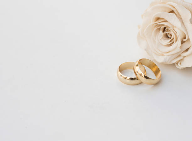 istock Golden wedding rings and a white rose 1275853878