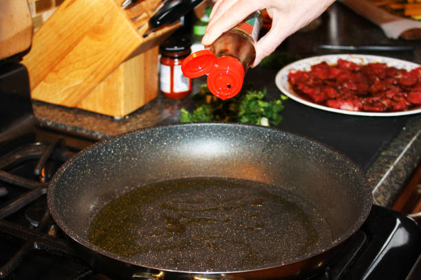 istock Adding oil to a frying pan 1275854037