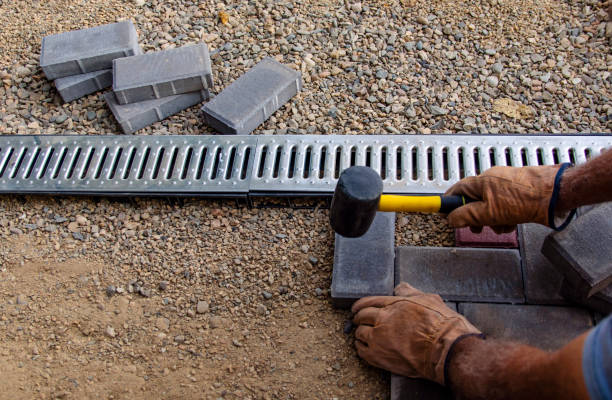 istock A gloved craftsman lays paving stones in layers. Brick paving slabs for professional use. Laying gray concrete paving slabs in the courtyard of the house on a sandy foundation. 1275855228