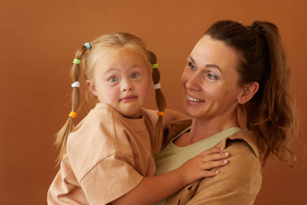 Mother Holding Girl with Down Syndrome in Studio