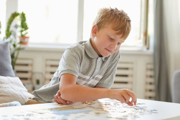 istock Smiling Teenage Boy Playing with Puzzle Game 1275856718