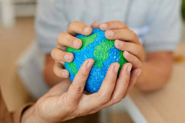 family holding planet model close up - earth globe mother child imagens e fotografias de stock