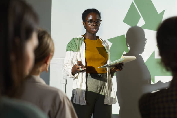 African-American Woman Presenting at Eco Conference Portrait of young African-American woman giving speech on recycling and waste management during eco conference sustainable lifestyle stock pictures, royalty-free photos & images