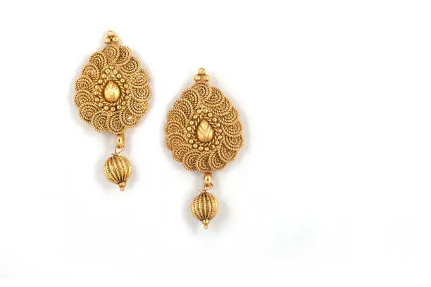 Beautiful Golden pair of earrings on white background. Luxury female jewelry, Indian traditional jewellery, kundan earrings,Bridal Gold earrings wedding jewellery