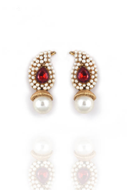 白い背景に赤い宝石を持つピアス真珠の美しいペア。高級女性ジュエリー、インドの伝統的なジュエリー、ブライダルゴールドイヤリングウェディングジュエリー - antique traditional culture earring pair ストックフォトと画像