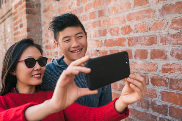 istock Asian couple taking a selfie with mobile phone. 1275859836