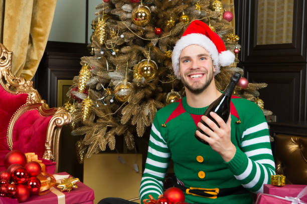 istock Guy in santa hat smile with champagne bottle 1275859905