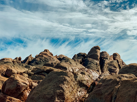 A shot of a beautiful rocky landscape in the Australian outback with a blue sky and lovely cloud formations.