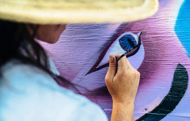 istock Hand of Female mural artist at work 1275860502