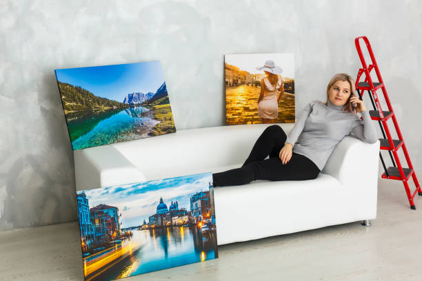 istock Girl hanging a frame canvas on a gray wall 1275863246