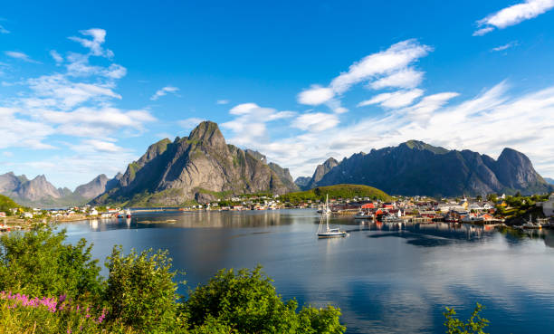 Reine  Fishing Village in Lofoten Islands, Norway This image shows day time view of Reine Village in Lofoten Islands, Norway. Ocean, mountian and fishing village can be seen in the image. reine lofoten stock pictures, royalty-free photos & images