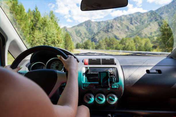 women's hands behind the wheel of a japanese honda car with a view of the mountain ranges through the windshield and the serpentine road. - rules of the road imagens e fotografias de stock