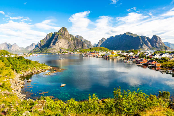 rorbuerhütten bei reine, lofoten, norwegen - mountain peak norway reflection sunlight stock-fotos und bilder