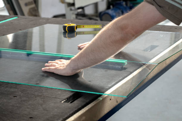 istock Glazier cuts and breaks glass on a professional table in the workplace 1275866046