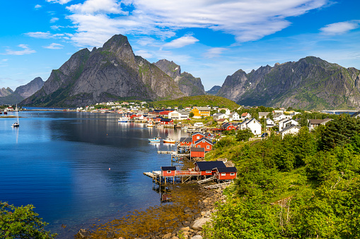 This image shows fishing huts near Reine inLofoten islands, Norway . Colorful wooden huts, ocean and mountian can be seen in the image.