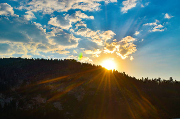 Photo of Gorgeous sun rays beam across mountains under bright blue sky