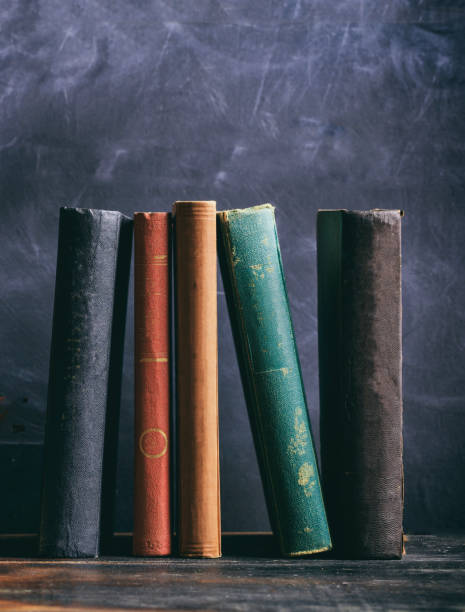 istock Vintage old books on blackboard background, vertical 1275868467