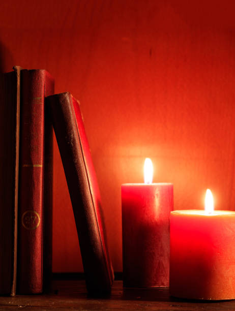 vintage alte bücher und kerzen, rote farbe hintergrund - bible candle book law stock-fotos und bilder
