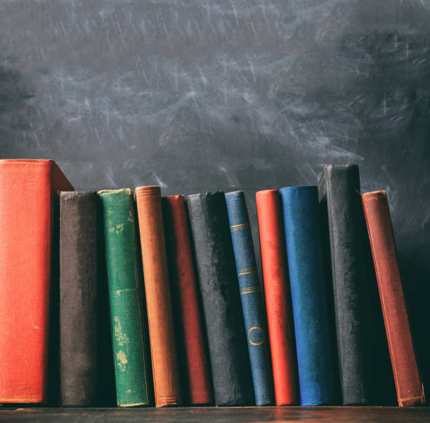 istock Vintage old books on blackboard background, copy space 1275868486