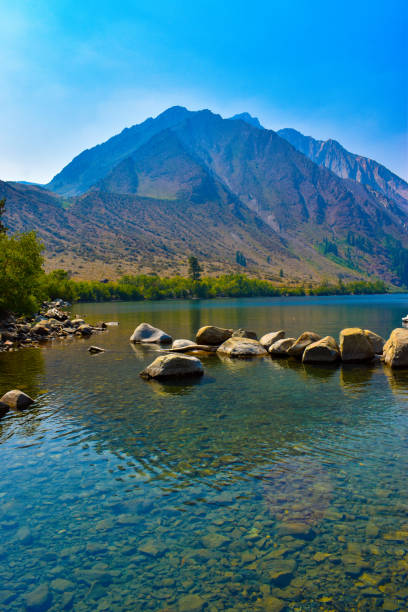 pristine clear alpine lake with tall mountain peaks background - trout fishing imagens e fotografias de stock