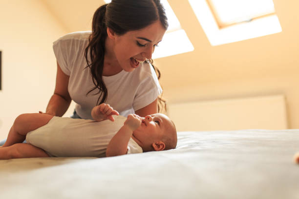 istock Mother playing with her baby on the bed . 1275870083