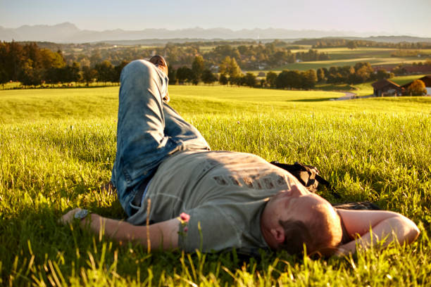 istock Mature man laying on a green meadow 1275870386