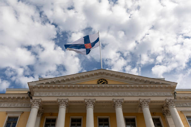 Helsinki, Finland - aut 9th 2020: State flag is flying over Finnish Government building downtown Helsinki. State flag differs from normal Finnish flag by having Finnish Lion implemented in it.