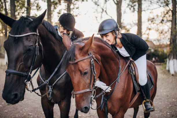 istock Two young female jockeys sharing love with horses 1275874306
