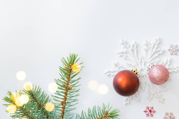 istock Flat lay frame with fir branches, christmas baubles decoration and gift box on a white background 1275877235