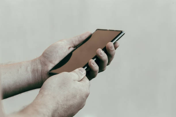 istock male hands holding a modern phone mock-up for your text message or information content, on a light blurred background 1275878373