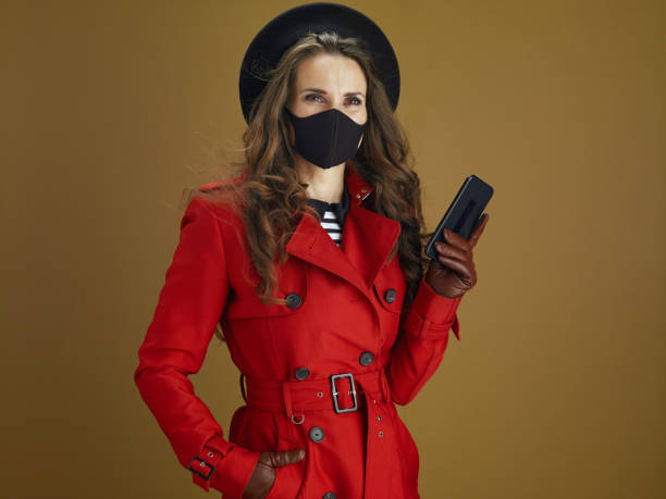 istock woman in coat isolated on brown background 1275879114