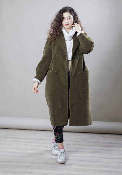 istock Young beautiful woman wearing a coat, studio shot 1275882818