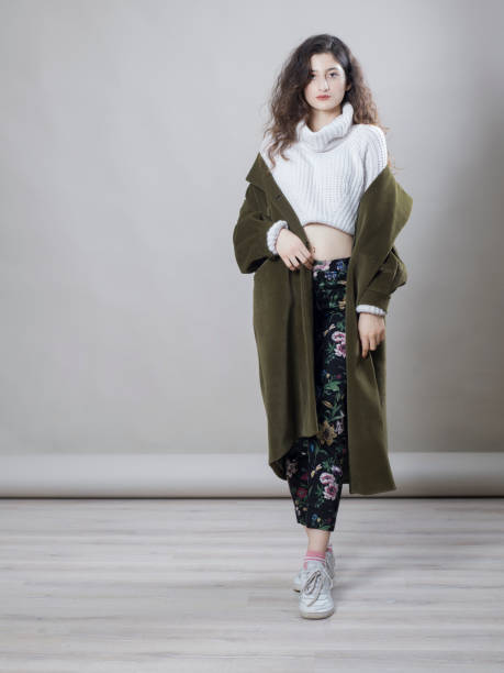 istock Young beautiful woman wearing a coat, studio shot 1275883687