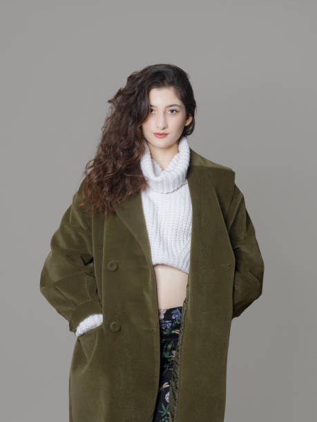 istock Young beautiful woman wearing a coat, studio shot 1275883744
