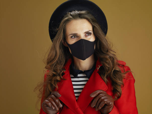 istock trendy woman in coat on brown background 1275883820